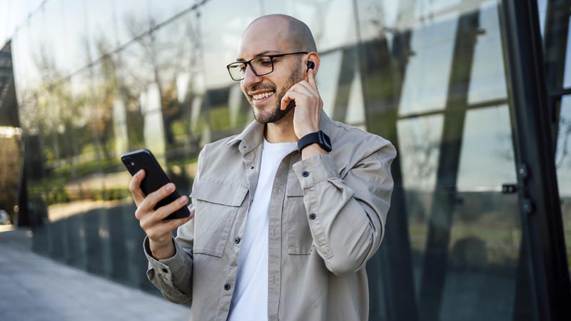 Homem com Samsung Galaxy Buds FE e telemóvel na mão